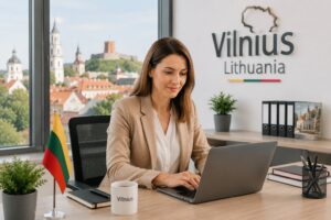 Українська жінка офісний працівник у литовській компанії пише на ноутбуці у сучасному офісі Вільнюса