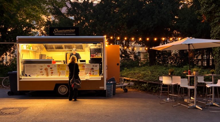 Фудтрак Shawarmino з освітленою зоною замовлення та столиками надворі